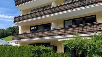 Un immeuble à plusieurs étages doté de balcons, d’un toit plat et d’une pelouse bien entretenue.