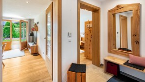 Een modern interieur met houten vloeren, een bank met kussen, een spiegel en een deur naar een balkon.