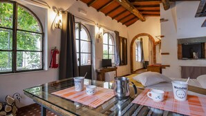 A cozy room with a glass table, a bed with pillows, and a wooden ceiling. - Cosy apartment for 2 people with private pool, TV, patio and pets allowed (Barga)
