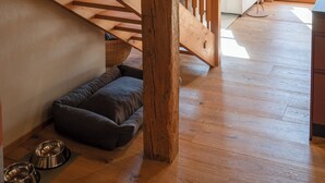 Un escalier en bois mène à un espace de vie comprenant un canapé et une lampe.