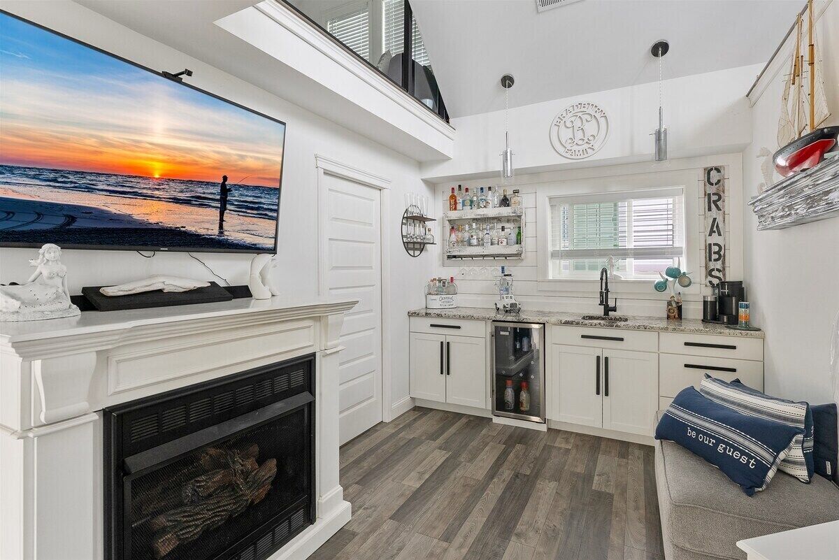 Una cocina moderna con chimenea, un televisor grande y una zona de bar con un letrero que dice 'CRABS'.