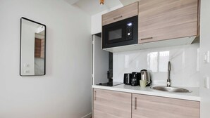 A compact kitchen with a microwave, coffee maker, and sink. - Peaceful Studio -2P- Moulin Rouge (Paris)