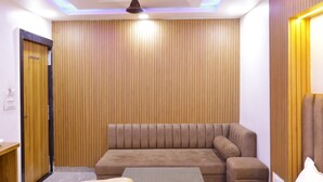 Una sala moderna con un sofá marrón, una mesita y un ventilador de techo.