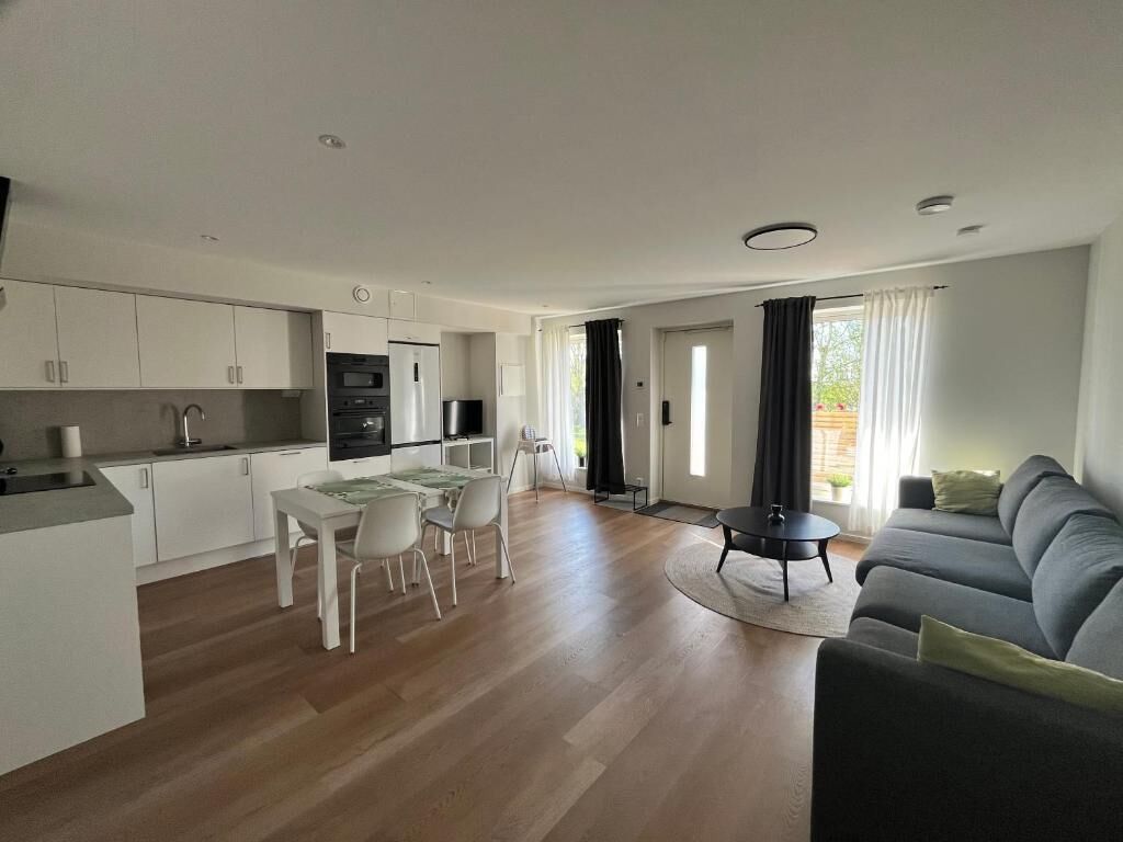 Un appartement moderne comprenant une cuisine, un coin repas et un salon.