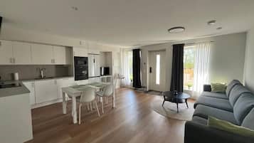 Un appartement moderne comprenant une cuisine, un coin repas et un salon.
