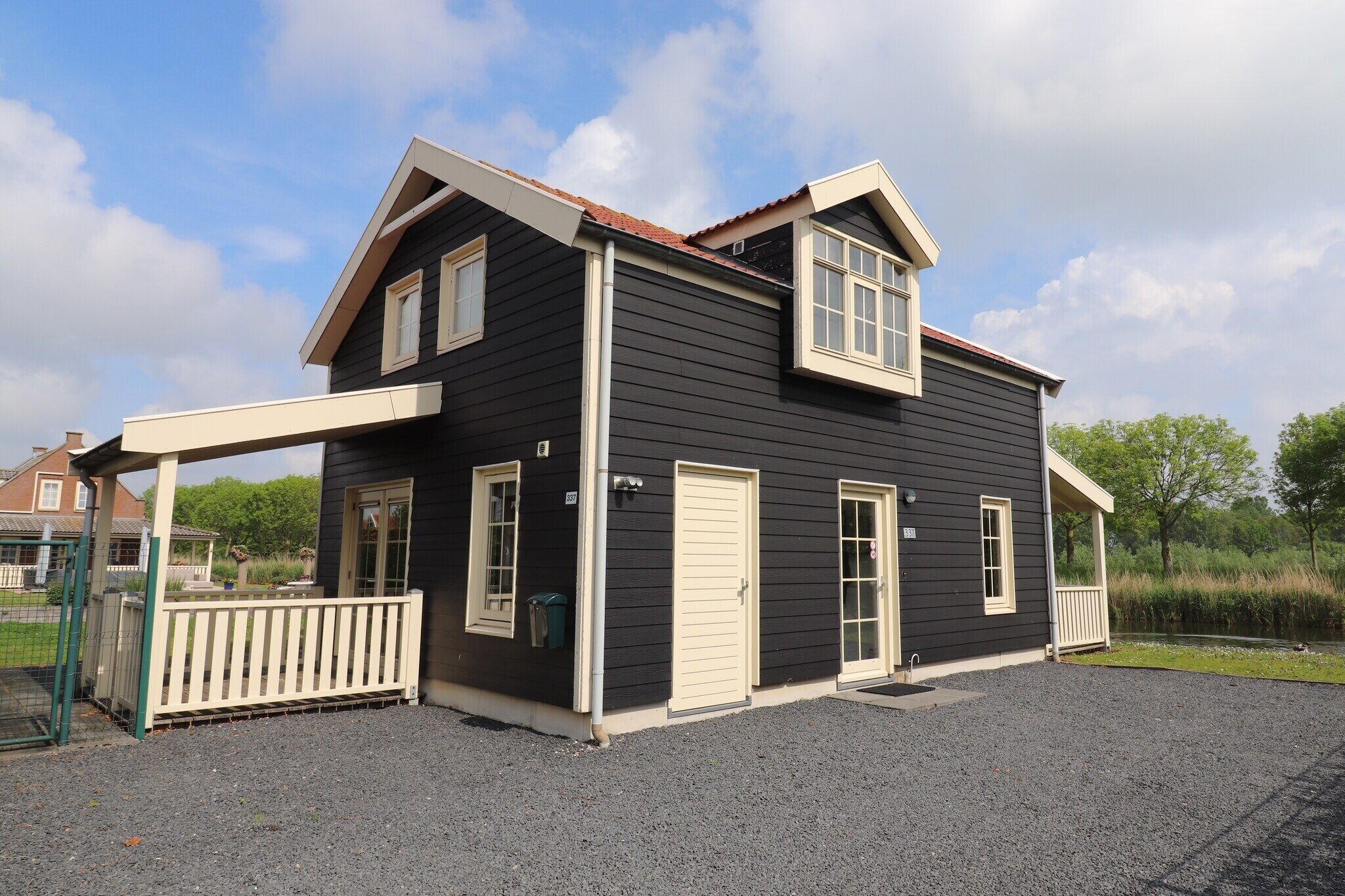 A two-story building with a covered porch, a front door, and a small window.