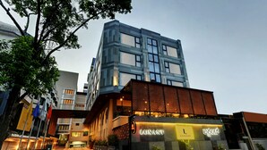 Un edificio moderno con un llamativo letrero 'LUXANT', que presenta una fachada combinada de vidrio y ladrillo, y una entrada bien iluminada.