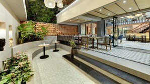 Un espacio interior moderno con zona de estar, una escalera y vistas al exterior.