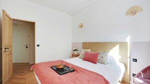 Une chambre à coucher avec un lit, une table de chevet et un ventilateur.