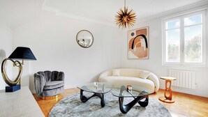 Una sala de estar moderna con una mesa redonda, un sofá y una lámpara.