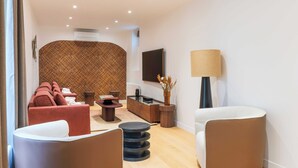A modern living room with a sofa, armchairs, a coffee table, and a TV. - Magnificent apartment - 4BR/10P - Arc de Triomphe (Paris)