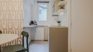 Una cocina pequeña con ventana, un lavabo y una encimera.