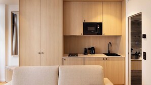 A compact kitchen with a microwave, kettle, and sink, adjacent to a seating area. - Beautiful Apartment - 1BD/4P - Quartier Latin (Paris)