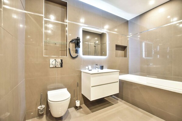Une salle de bain moderne avec un meuble-lavabo blanc, un grand miroir et une baignoire.