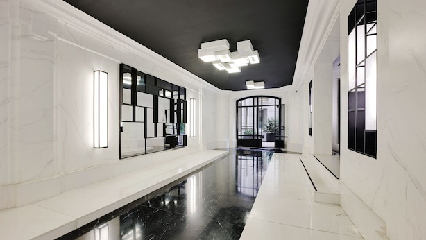 A modern hallway with white marble walls, black flooring, and contemporary lighting fixtures. - Superb apartment with terrace 2BR/4P Trocadero (Paris)