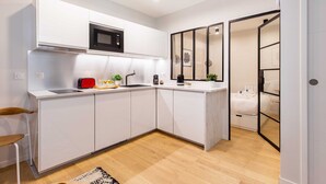 Una cocina moderna con armarios blancos, un microondas y un tostador.