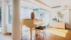 A spacious room with a grand piano, large windows, and a minimalist decor. - Exceptional apt with garden - 3BR/6P - Vincennes (Vincennes)