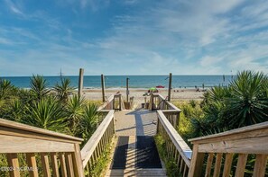 A wooden staircase leading to a beach with palm trees and a clear sky. -  4bedroom beach front, breathtaking, spacious, updated (Atlantic Beach)