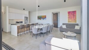 A modern interior with a dining area, kitchen, and living space. - Protaras Aqua Pearl Villa Aq11 (Paralimni)