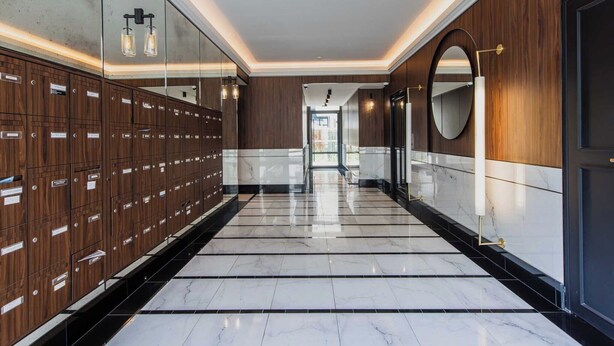 A modern hotel corridor with wooden lockers, marble flooring, and a mirrored wall. - Classy appartement - Flea Market (Saint-Ouen-sur-Seine)