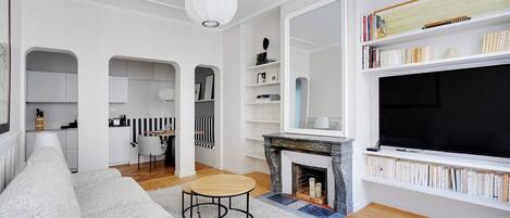 Un salon moderne avec une cheminée, un canapé, une table basse et une bibliothèque.
