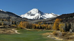 Een golfbaan met een berg op de achtergrond.
