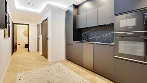 Eine moderne Küche mit dunklen Schränken, einem Kühlschrank von Bosch und einer Mikrowelle.