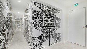 A hallway with a unique black and white patterned wall and a sign that reads "Welcome to Madame Pontieu". - Charming apartment - 1BR/4P - Faubourg-du-Roule (Paris)