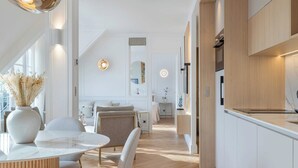 Een moderne keuken met witte kasten en een houten aanrecht.