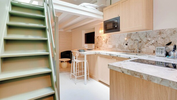 Eine moderne Küche mit Einbau-Mikrowelle, Marmorarbeitsplatte und Holzschrank.