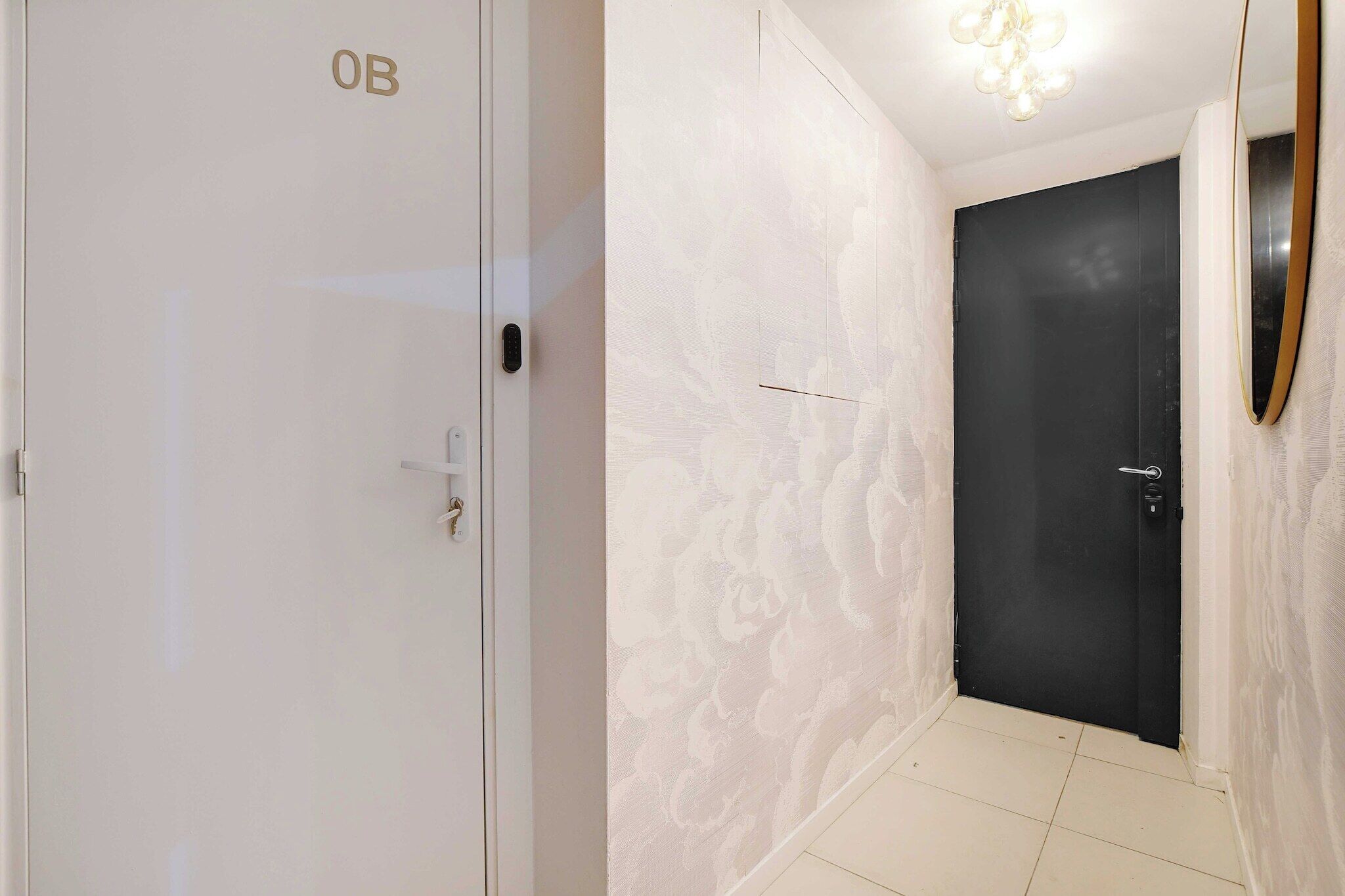 Um corredor com uma porta branca identificada com 