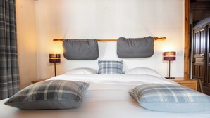 Un letto rifatto con due cuscini, due lampade da comodino e una testiera con altri due cuscini.