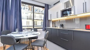 Eine moderne Küche mit integriertem Mikrowellenherd, einer Kaffeemaschine und einem roten Toaster.