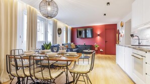 Une cuisine moderne avec des armoires blanches, un four encastré et un plan de travail.