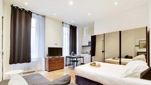 Een moderne hotelkamer met een bed, een bureau, een stoel, een bank en een kledingkast.