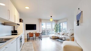 Ein modernes Apartment mit Küche, Essbereich und Wohnzimmer.