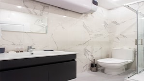 A modern bathroom with a marble backsplash, a black vanity, a white toilet, and a glass shower enclosure. - Magnificent apartment - 1BR/4P - Picpus (Paris)