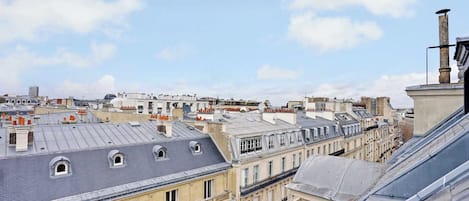 Une vue sur un paysage urbain avec de nombreux bâtiments, dont un bâtiment imposant doté d’un grand dôme et d’une cheminée.