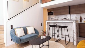 A modern kitchen with a marble countertop, wooden cabinets, and a built-in oven.