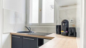 Een moderne keuken met een zwart aanrecht, een spoelbak en een raam.