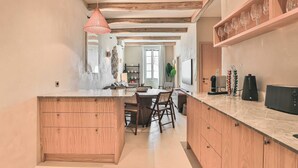 Een moderne keuken met een centraal eiland, houten kastjes en een hanglamp.
