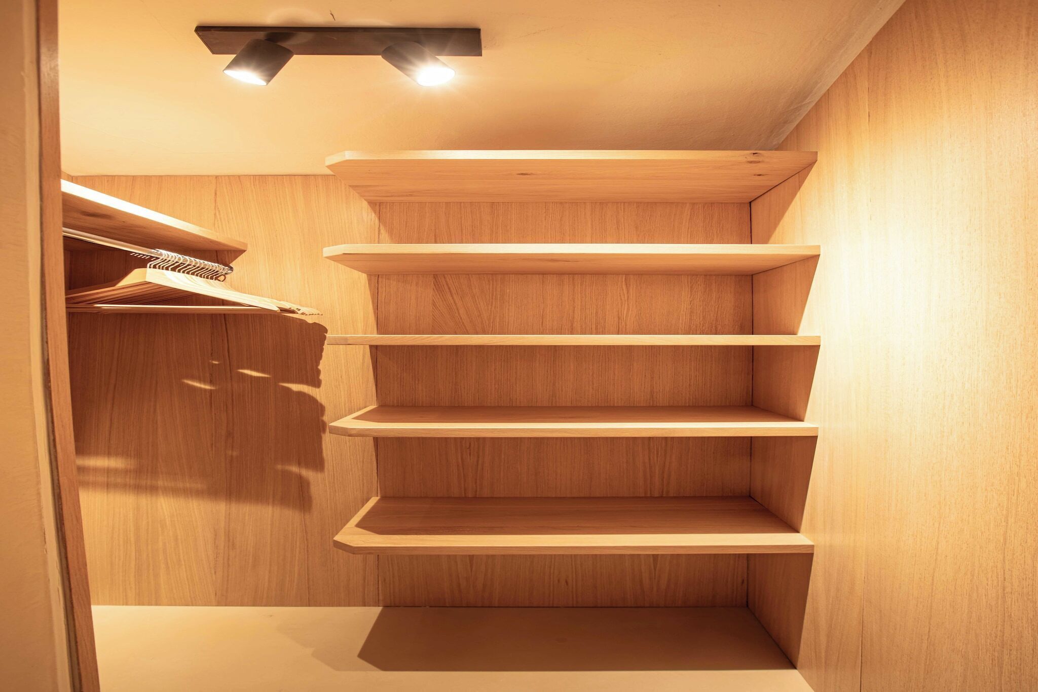 Un armadio in legno con ripiani multipli e un appendiabiti.