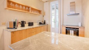 Een moderne keuken met houten kastjes, een marmeren aanrechtblad en een ingebouwde wijnrek.