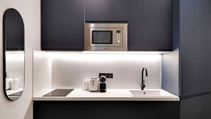 A modern kitchen with a built-in microwave, a coffee maker, and a sink.