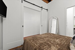 A bedroom with a bed, a wardrobe, and a mirror. - Oak St. Loft #2 - Walk to T-Mobile, P&L, Streetcar (Kansas City)