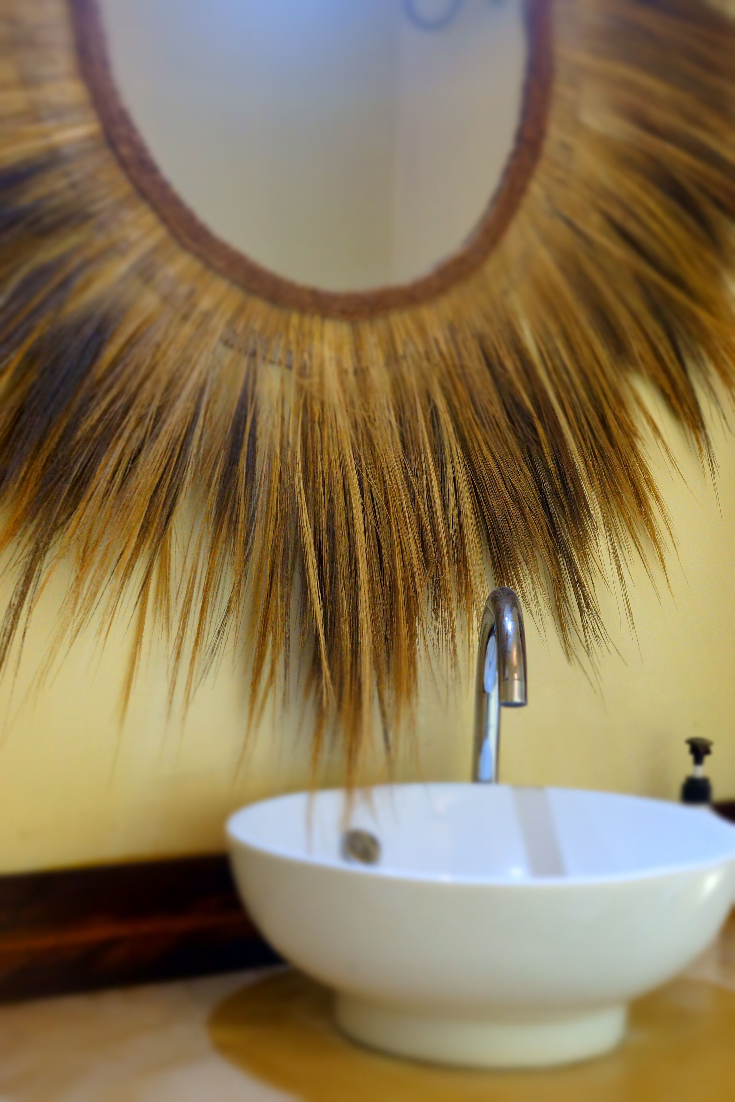 Un baño con un lavamanos blanco y un espejo de marco marrón.