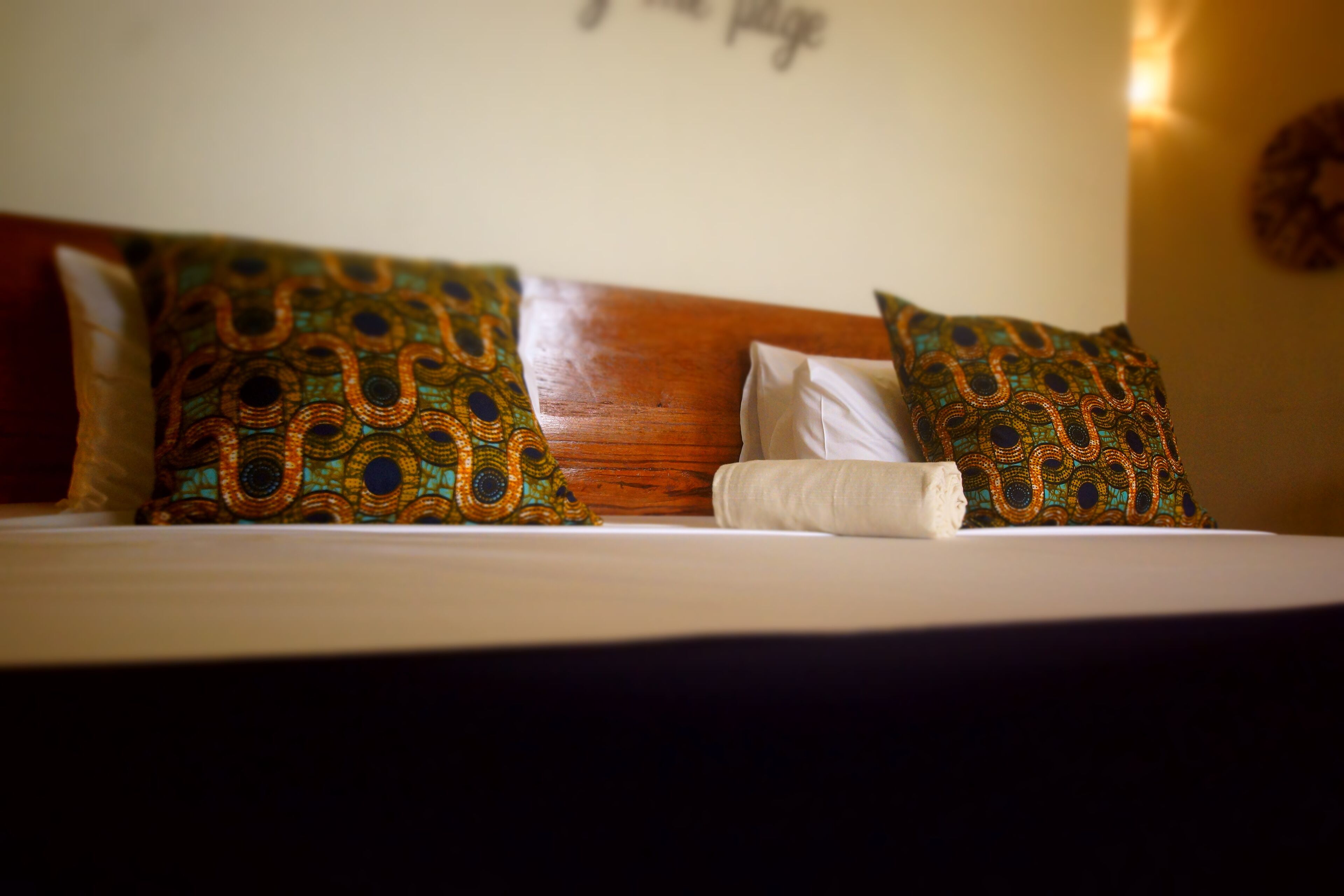 A bed with patterned pillows and a wooden headboard.