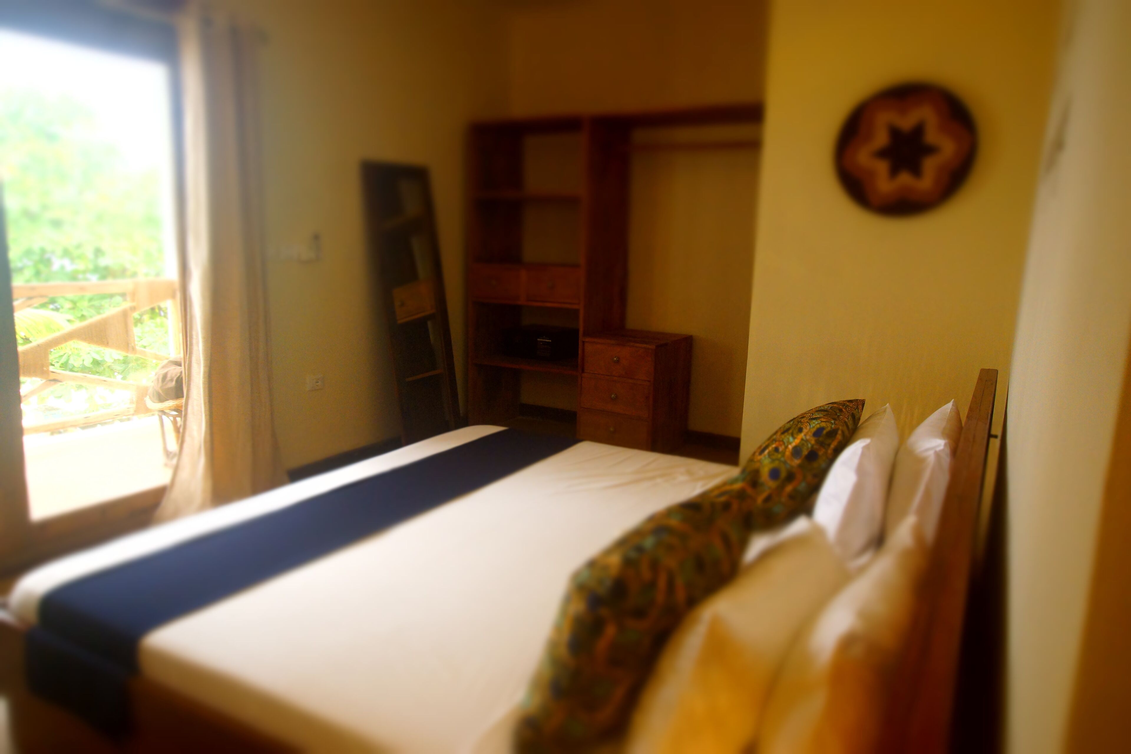 A bedroom with a bed, a wardrobe, and a small desk.