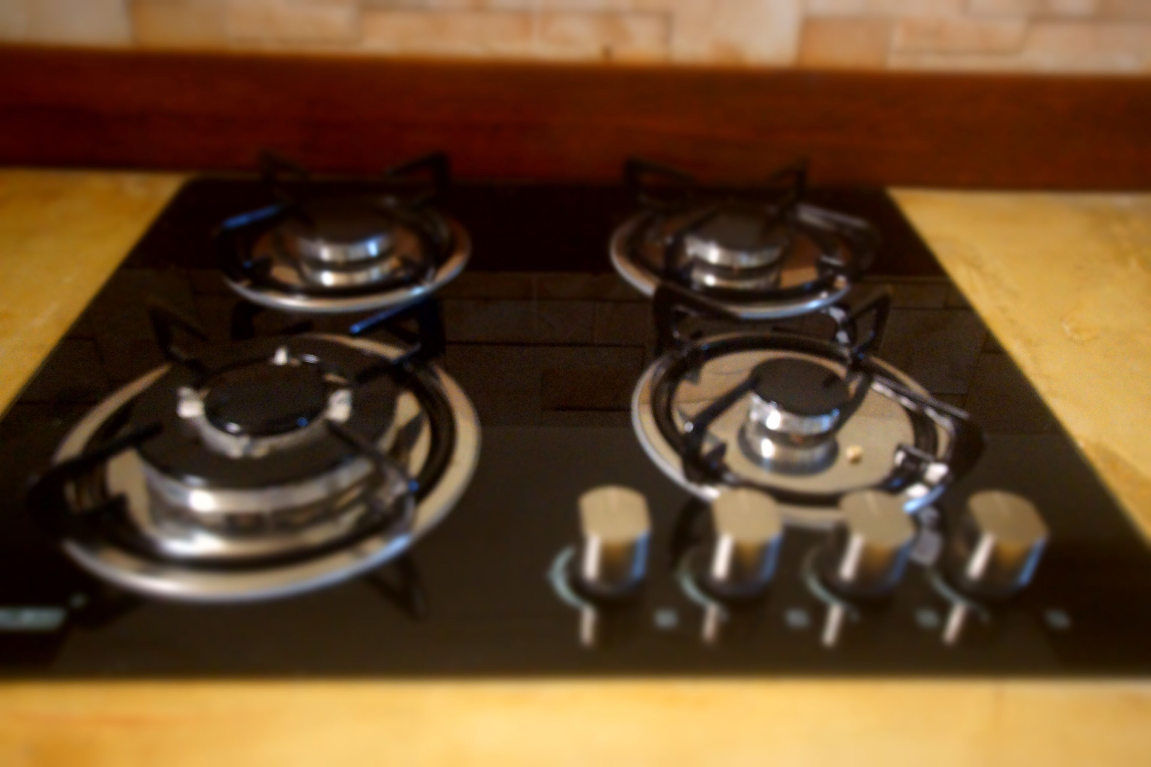 A kitchen with four burners and a stove top.