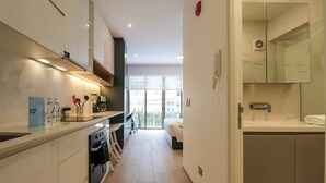 A modern kitchen with a built-in oven, a coffee machine, and a small dining area. - w* | Superb Loft w/ Balcony in Barranco (Lima)